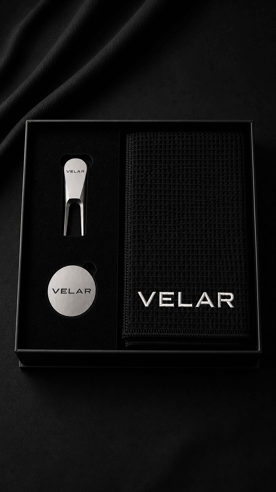 VELAR golf gift set in its matte-black presentation box with silver divot tool, ball marker and embroidered golf towel